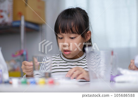 Cute little girl making DIY plaster and painting at home. Children paint on plaster sculptures with family on holiday. Imagination and creativity activities. 105686588