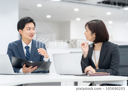 Young male and female businessmen having a meeting in the office 105690203