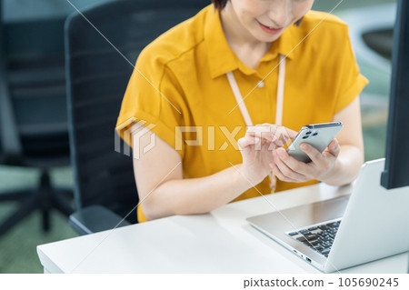 使用計算機和智能手機在辦公室工作的年輕女工程師 105690245