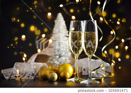 Two champagne glasses and christmas decorations on a dark festive background. Happy New Year. Two champagne glasses and christmas decorations on a dark festive background. Happy New Year. 105691471