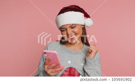 Happy excited woman use mobile phone say wow yes found out great big win news doing winner gesture 105691902