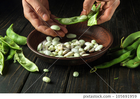 Chef cleaning green beans in the kitchen table. Close-up of cook hands while working. Organic peasant food 105691959