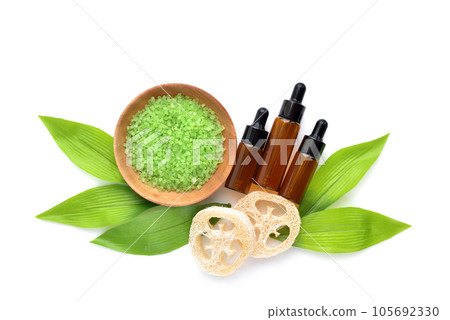 Organic spa cosmetic - bath salt, bottles of essential oils and green leaves on white background 105692330