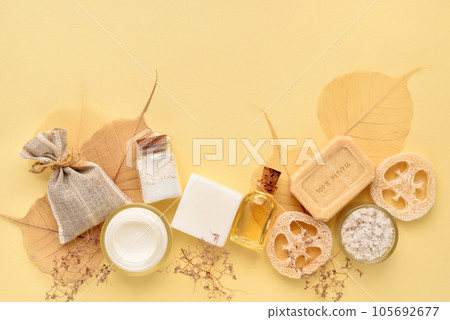 Organic cosmetic - bath salt, cream, bottles of essential oils, soap on a yellow pastel background. 105692677