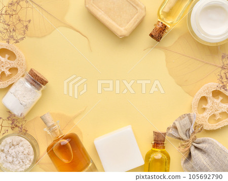 Organic cosmetic - bath salt, cream, bottles of essential oils, soap on a yellow pastel background Organic cosmetic - bath salt, cream, bottles of essential oils, soap on a yellow pastel background 105692790