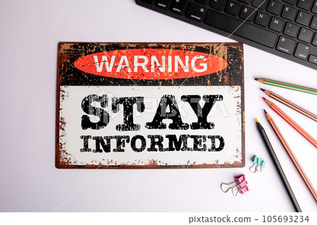 Stay Informed Concept. Warning sign on a white office desk Stay Informed Concept. Warning sign on a white office desk 105693234