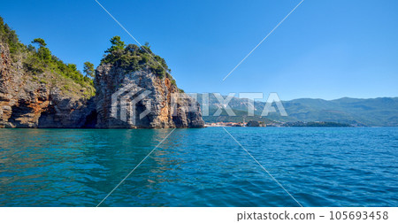 Picturesque view on rocks on a sunny day from the sea. Budva riviera, Montenegro Picturesque view on rocks on a sunny day from the sea. Budva riviera, Montenegro 105693458