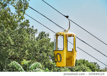 Yellow cabin of overhead cable car against blue sky Yellow cabin of overhead cable car against blue sky 105694120