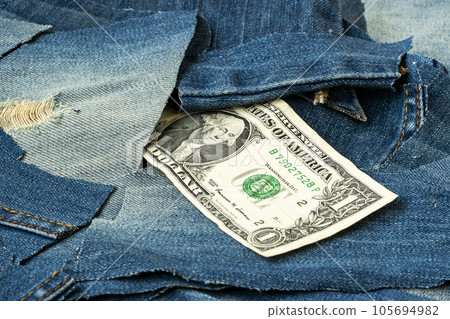 One dollar banknote in the pile of  blue jean scrap 105694982