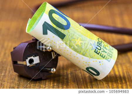 One hundred Euro banknote and electrical plug. Concept of saving electricity at home. 105694983