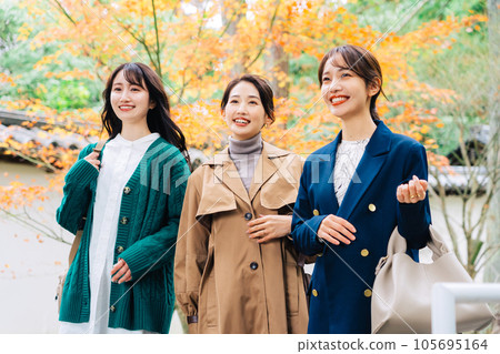 A group of three women traveling in the autumn leaves season A group of three women traveling in the autumn leaves season 105695164