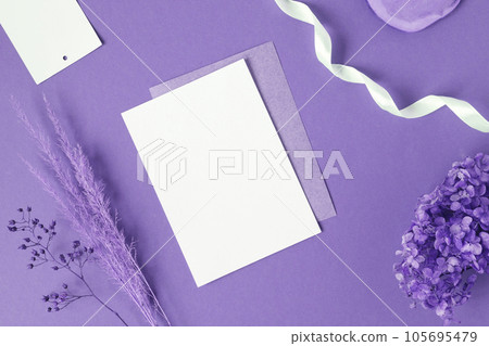 Blank greeting card, invitation mockup. Dry grass, pampas plant on violet table background. Flat lay, top view. Copyspace. Paper cards, mock up. Modern Minimal business brand template. Soft shadow, A6 105695479