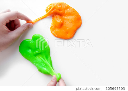 Playing with textured slime with bubbles, stretching the gooey substance. Female teen hand holding blue shining slime, squeezing it. Adorable Girl stretching slime toy to the sides. Liquid toy. 4K Playing with textured slime with bubbles, stretching the gooey substance. Female teen hand holding blue shining slime, squeezing it. Adorable Girl stretching slime toy to the sides. Liquid toy. 4K 105695503