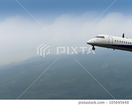 Passenger plane flying over mountains 105695648