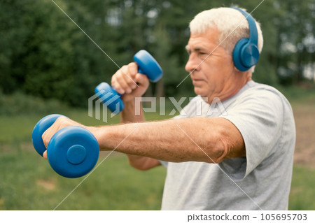 Senior man working out outdoors. Person lifting dumbbells. Old male exercising at park. Healthy people lifestyle. Active sport training. Older elderly sportsman doing fitness exercise. Workout session 105695703