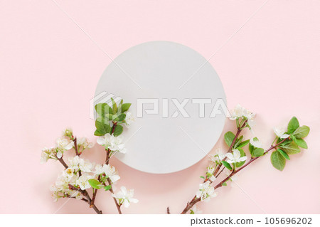 Round Podium with flowering apple branches for product presentation. Abstract minimal geometrical form on pink background. One Showcase, white flowers, soft shadow. Scene, display. Top view, Flat lay Round Podium with flowering apple branches for product presentation. Abstract minimal geometrical form on pink background. One Showcase, white flowers, soft shadow. Scene, display. Top view, Flat lay 105696202