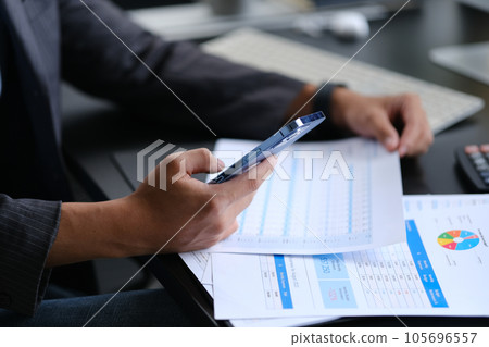 Businessman taking a break from work and checking social media on smartphone Businessman taking a break from work and checking social media on smartphone 105696557