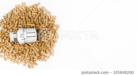Wooden Pellets with Thermostat. Thermostatic Valve Head Isolated on White Background. Renewable Source of Heating. Biofuel. Ecologic Fuel made from Biomass. The Alternative Energy Source. Gas Crisis. Wooden Pellets with Thermostat. Thermostatic Valve Head Isolated on White Background. Renewable Source of Heating. Biofuel. Ecologic Fuel made from Biomass. The Alternative Energy Source. Gas Crisis. 105698200