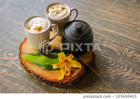 Tasty coffee served in the garden on old wooden table Tasty coffee served in the garden on old wooden table 105698403