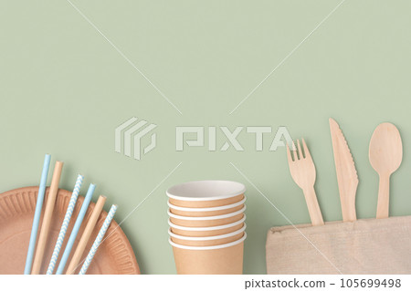 Eco - Friendly Tableware on Green Background. Top View. Plastic free Set of Brown Paper Utensil. Street Food Recyclable Packaging. Zero waste Paperware. Mockup. Disposable Take out Cup, wooden cutlery Eco - Friendly Tableware on Green Background. Top View. Plastic free Set of Brown Paper Utensil. Street Food Recyclable Packaging. Zero waste Paperware. Mockup. Disposable Take out Cup, wooden cutlery 105699498
