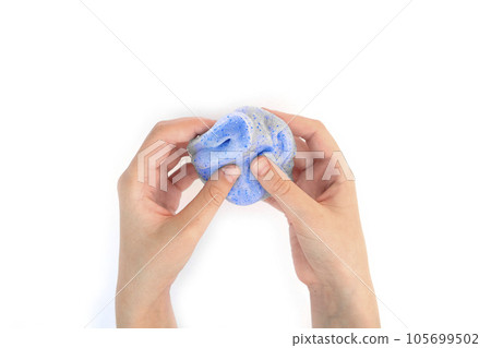Hand Playing with textured slime on white background. Teen hand holding blue shining slime with bubbles, stretching the gooey substance. Teenage Girl squeezing slime toy to the sides. Liquid toy Hand Playing with textured slime on white background. Teen hand holding blue shining slime with bubbles, stretching the gooey substance. Teenage Girl squeezing slime toy to the sides. Liquid toy 105699502