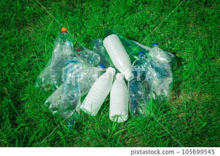 Plastic bottles and bottle caps on grass. Plastic bottles and bottle caps on grass. 105699545