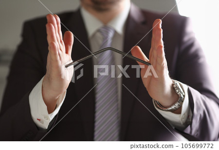 Male hands bend nail metal between palm 105699772
