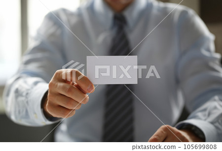 Male arm in suit give blank calling card to visitor 105699808