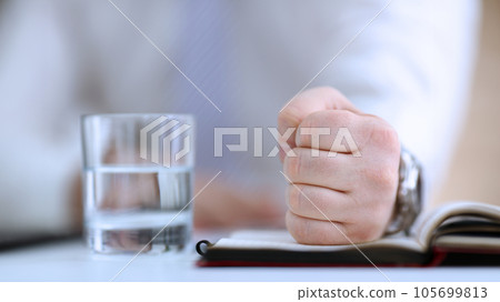 Male clenched fist in suit at office Male clenched fist in suit at office 105699813