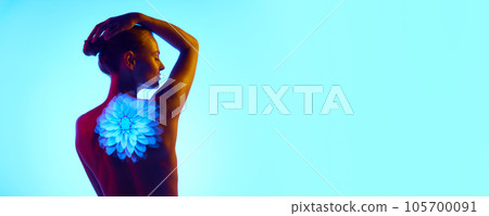 Banner. Back view. Beautiful young slim woman with digital neon projector lights showing flowers over vivid cyan background. Copy space for ad. Banner. Back view. Beautiful young slim woman with digital neon projector lights showing flowers over vivid cyan background. Copy space for ad. 105700091