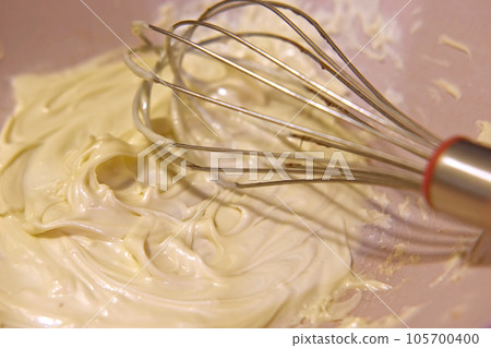 Preparing whipped liquid white chocolate. melted chocolate in a mixing bowl. Top view. Closeup of molten hot chocolate swirl. Confectionery. Pouring premium milk chocolate. Prepare dessert, icing Preparing whipped liquid white chocolate. melted chocolate in a mixing bowl. Top view. Closeup of molten hot chocolate swirl. Confectionery. Pouring premium milk chocolate. Prepare dessert, icing 105700400