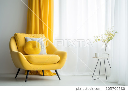 A yellow armchair stands near the window in the interior A yellow armchair stands near the window in the interior 105700580