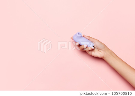 Female hand with vibrator, medical massager over pastel pink background. Image for sex shop. Concept of woman health, medicine, ad Female hand with vibrator, medical massager over pastel pink background. Image for sex shop. Concept of woman health, medicine, ad 105700810