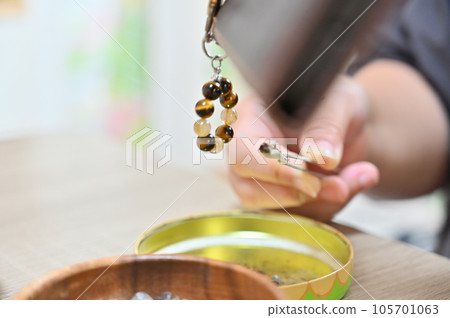 Palo Santo Woman purifying a power stone with white sage 105701063