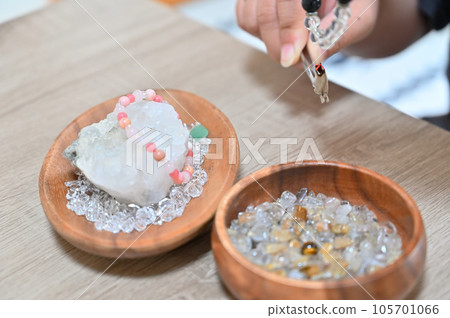 Palo Santo Woman purifying a power stone with white sage 105701066