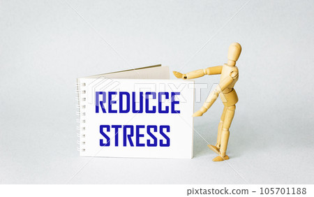 Medical concept. Wooden doll near notepad with text REDUCE STRESS on blue background 105701188