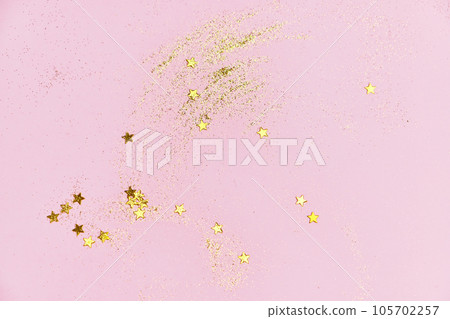 Golden glitter sequins and stars on a pink background. 105702257