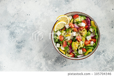 Delicious and healthy green salad of different leaves and vegetables with seeds and olive oil. 105704346