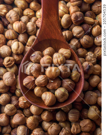 Peeled hazelnuts in close-up with wooden spoon. View from above. Promotional photo of healthy nut Peeled hazelnuts in close-up with wooden spoon. View from above. Promotional photo of healthy nut 105704539