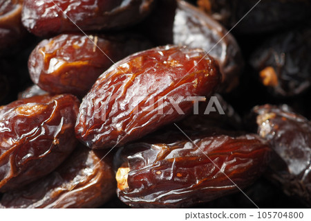 close up of fresh date fruit in a bowl on table close up of fresh date fruit in a bowl on table 105704800