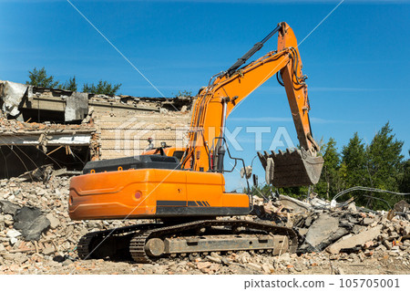 The excavator eliminates the consequences of an earthquake, clearing rubble from residential buildings 105705001