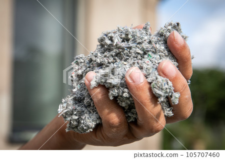 Cellulose insulation for walls and floors In hand. Recycled newsprint. Heat preservation and energy 105707460