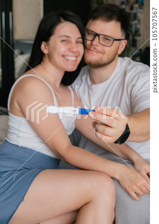 happy couple looking at positive pregnancy test 105707567