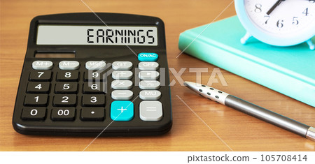 Business, Technology, Internet and network concept. Inscription EARNINGS word on calculator. Business, Technology, Internet and network concept. Inscription EARNINGS word on calculator. 105708414