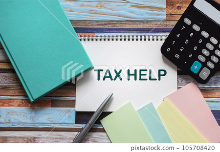 Notepad with text TAX AID with pen, office tools and calculator on desktop. 105708420