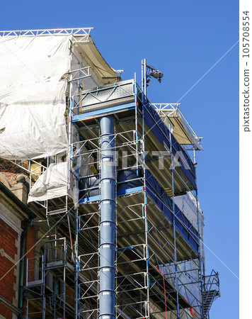 Restoration of the facade of a historic house using scaffolding and construction debris plastic pipe Restoration of the facade of a historic house using scaffolding and construction debris plastic pipe 105708554