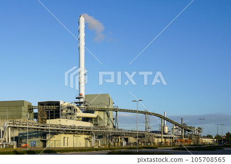 External view of large modern biomass cogeneration wood chip power plant with tall steam chimney External view of large modern biomass cogeneration wood chip power plant with tall steam chimney 105708565