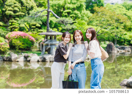 Women's trip Young women strolling through a Japanese garden while sightseeing in Osaka Castle 105708613