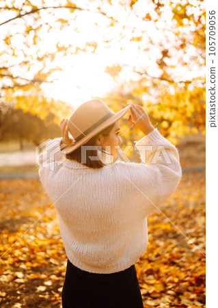 Sunny lifestyle portrait of young stylish woman walking on park, wearing cute trendy hat. Fashion concept. Sunny lifestyle portrait of young stylish woman walking on park, wearing cute trendy hat. Fashion concept. 105709056
