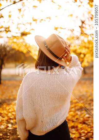 Sunny lifestyle portrait of young stylish woman walking on park, wearing cute trendy hat. Fashion concept. Sunny lifestyle portrait of young stylish woman walking on park, wearing cute trendy hat. Fashion concept. 105709057